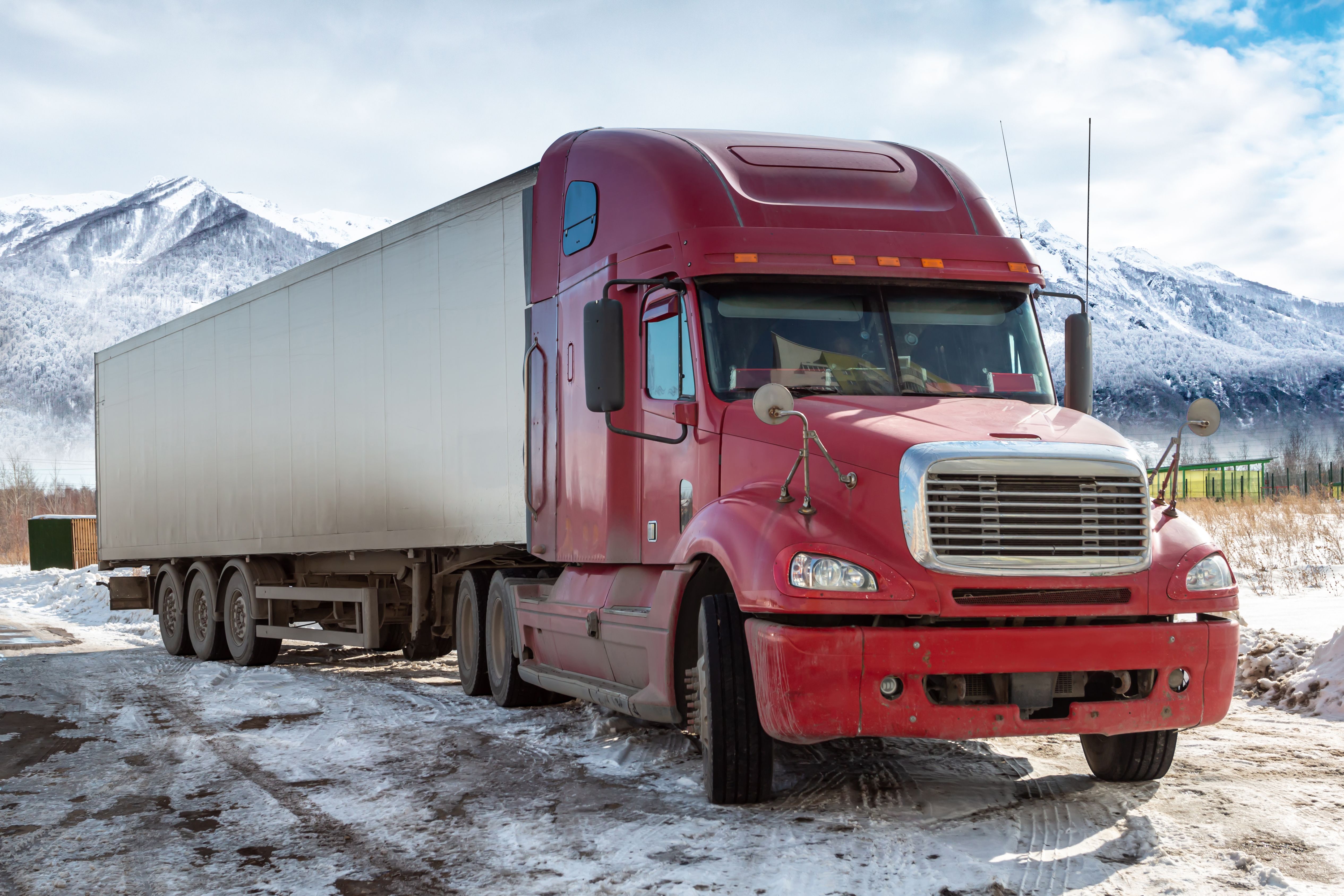 red long distance truck with semitrailer winter background high picturesque mountains
